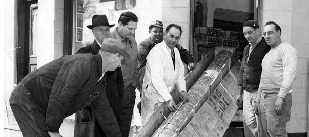 Frigo family and workers unloading wheels of cheese in front of the store