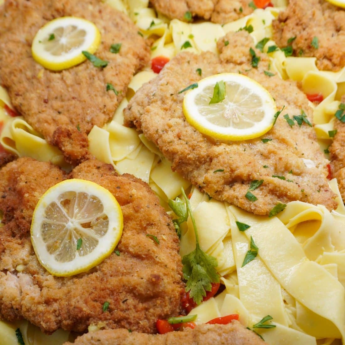 Chicken francaise with lemon slices over pappardelle