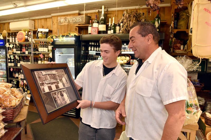 Joe Frigo and Nick Frigo looking at prior Frigo generation pictures