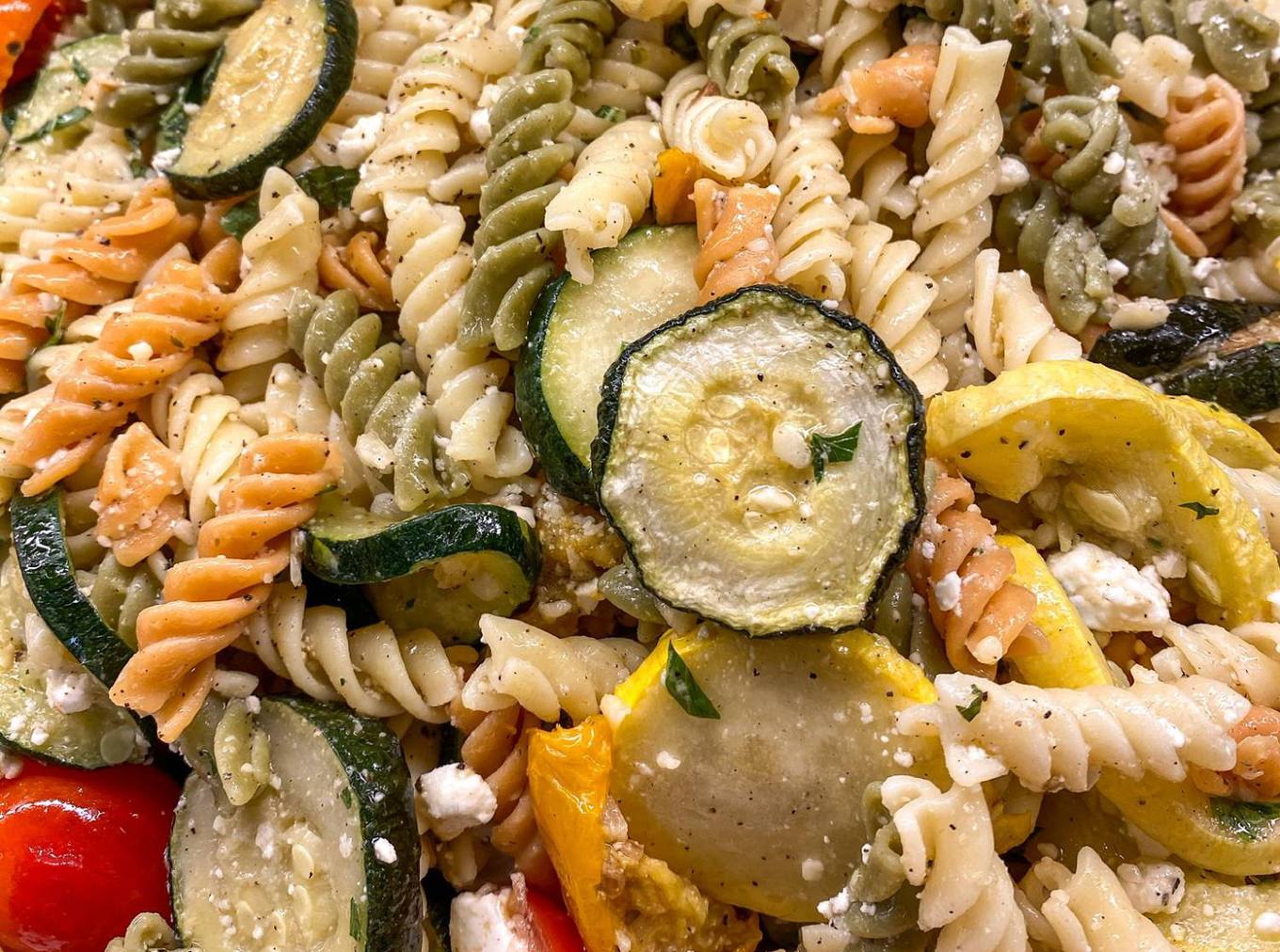 Home Tri-color rotini pasta salad with zucchini, yellow squash, tomatoes and feta
